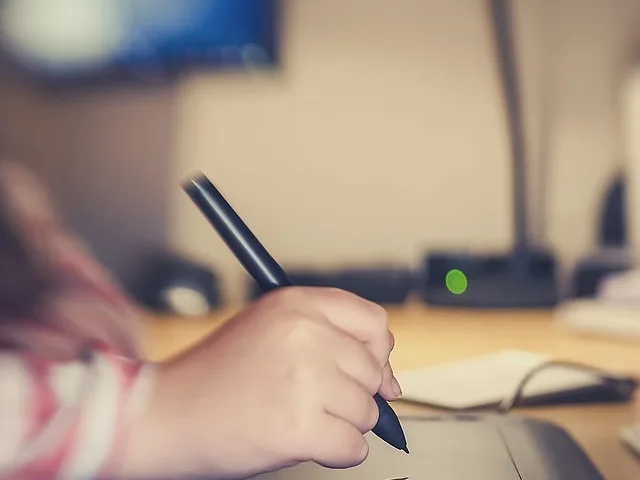 Grafikai táblán és digitális tollal dolgozó hallgató kéz-közeli felvétele